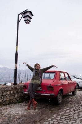 Andrina Sol blije pose bij rode auto in Ohrid