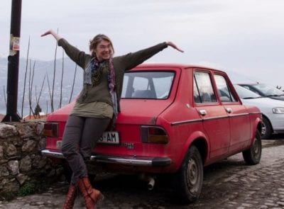 Andrina Sol blije pose bij rode auto in Ohrid