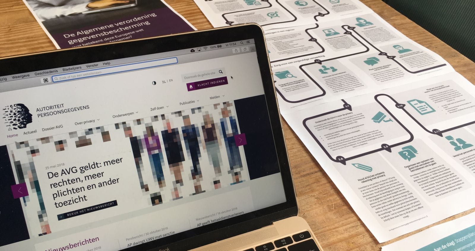 Autoriteit Persoonsgevens website over AVG op beeldscherm en folders op tafel